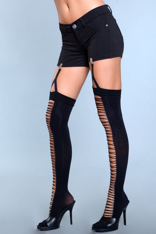 Black thigh-high stockings with cut-out design worn by a person on a light blue background