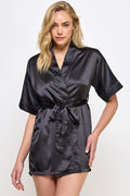 Woman wearing a black satin robe against a white background
