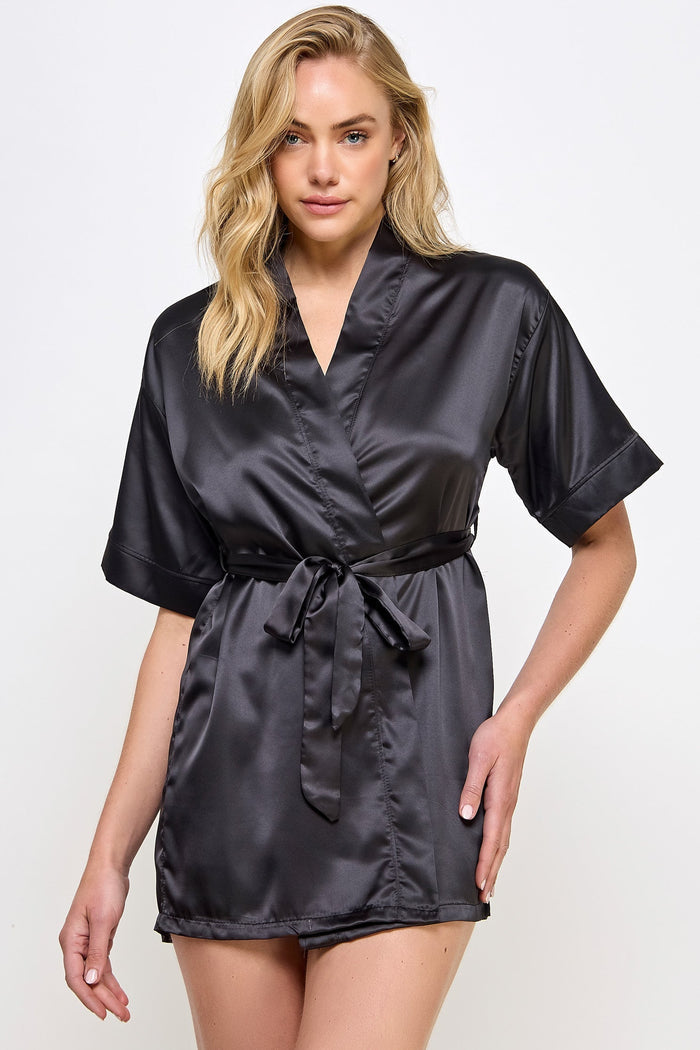 Woman wearing a black satin robe against a white background