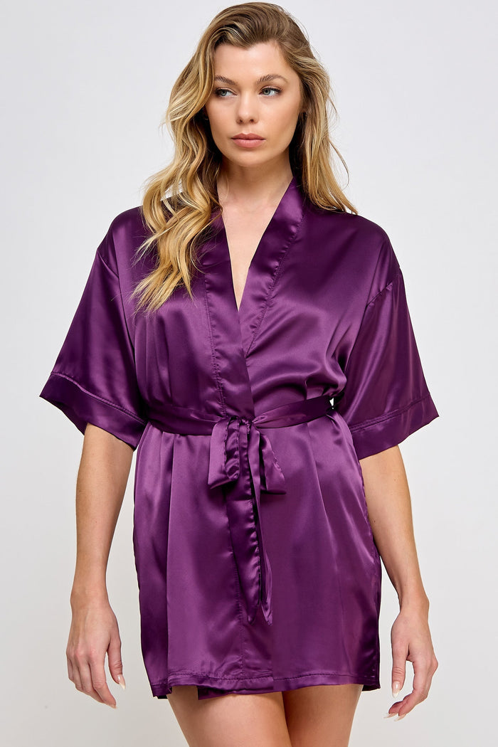Woman wearing a purple satin robe on a white background