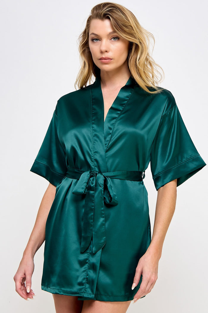 Woman wearing a green satin robe on a white background
