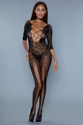 Model wearing a black lace bodystocking against a gray background