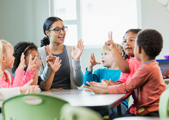 TEFL teacher using interactive learning techniques to engage young English language learners in a classroom overseas