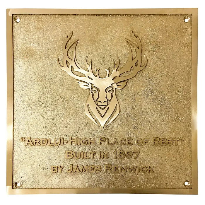 Custom engraved brass signage for homes | Handcrafted brass house plaque, gold plaque with deer emblem and text on a white background