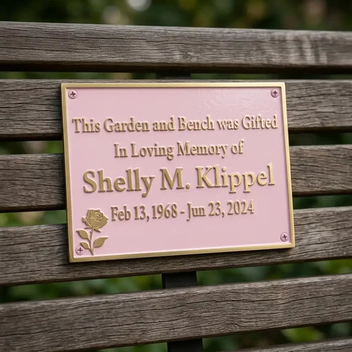 Memorial plaque on a bench dedicated to Shelly M. Klippel with a rose design.