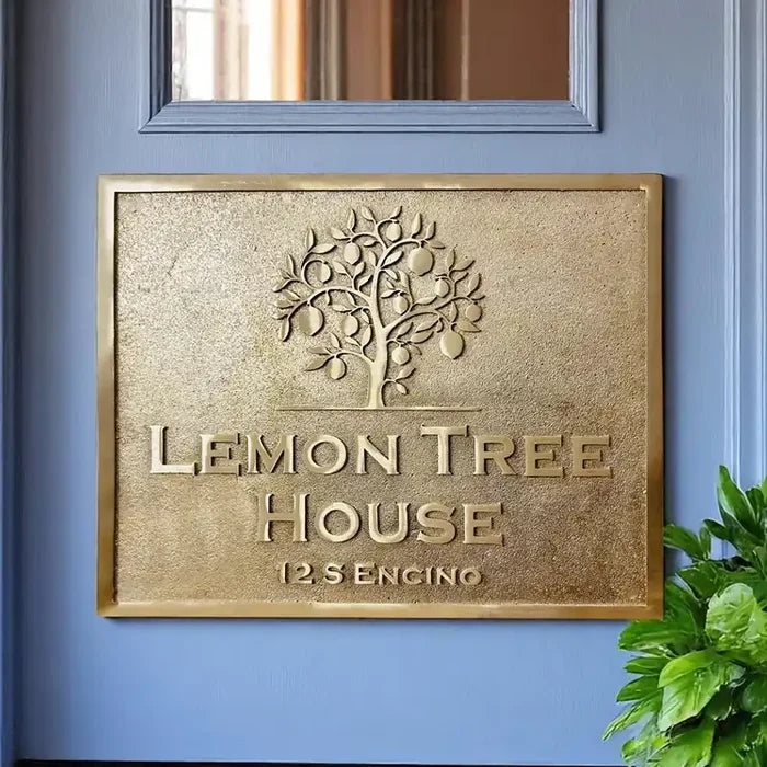 Brass address plaque with 'Lemon Tree House' on a blue wall.