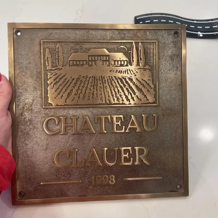 Custom brass address sign featuring engraved property name and street number.