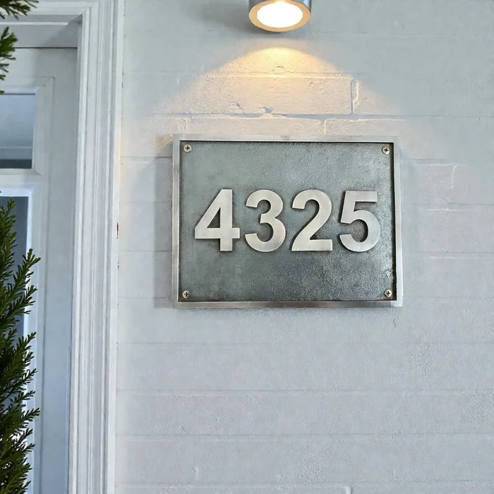 House number '4325' on a metal plaque mounted on a light gray wall.