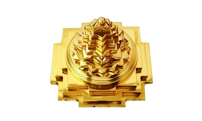 Gold decorative item with intricate design on a white background