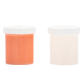 Two cylindrical containers with white lids, one orange and one beige, on a white background.