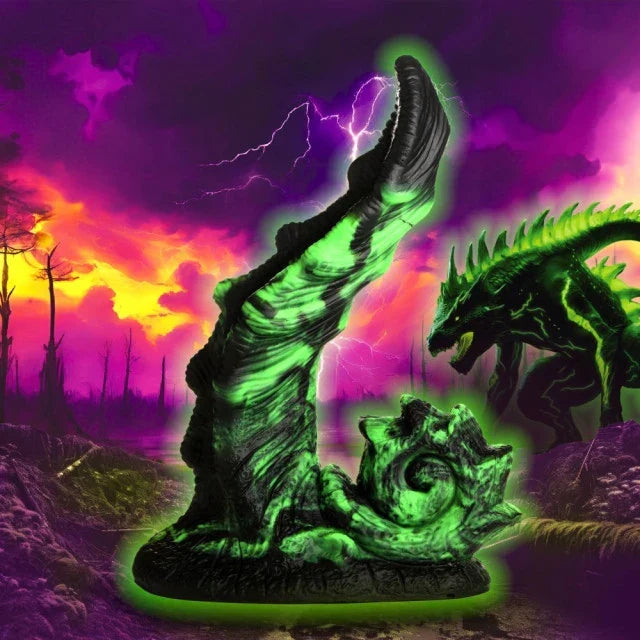 Glowing green dragon statue against a vibrant, fiery sky