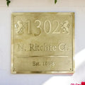 Gold house number plaque with '1302 N. Ritchie Ct. Est. 1898' on a white background