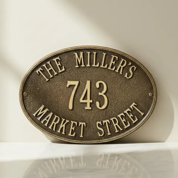 Bronze oval house number sign with 'The Miller's 743 Market Street' text on a white background
