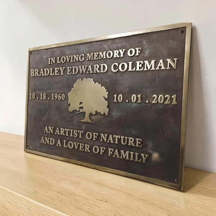 Brass Memorial plaque bronze color on a wooden surface with a white background