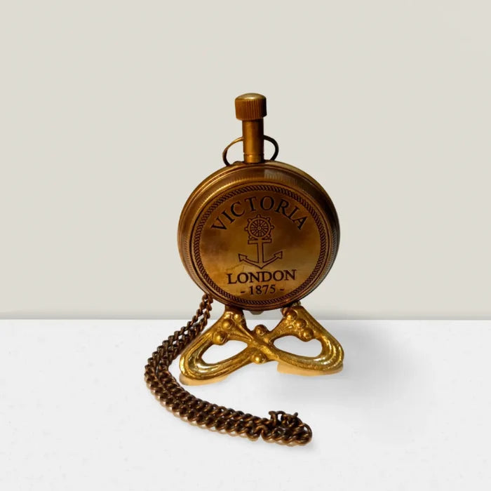 Antique brass pocket watch with a chain and a custom engraving on the back.