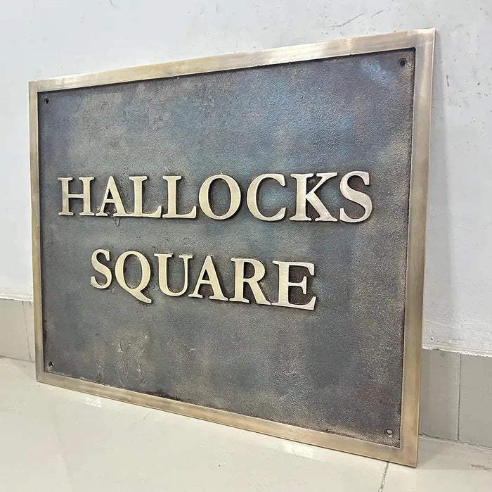 Metal sign with 'HALLOCKS SQUARE' text on a plain background, custom address sign brass