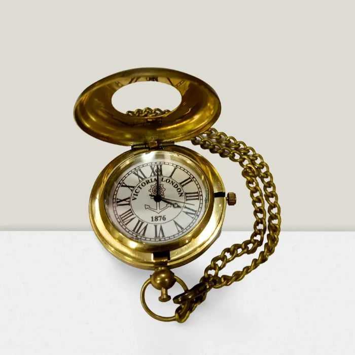 A gold-colored brass pocket watch with a chain and an open face showing the time and date.