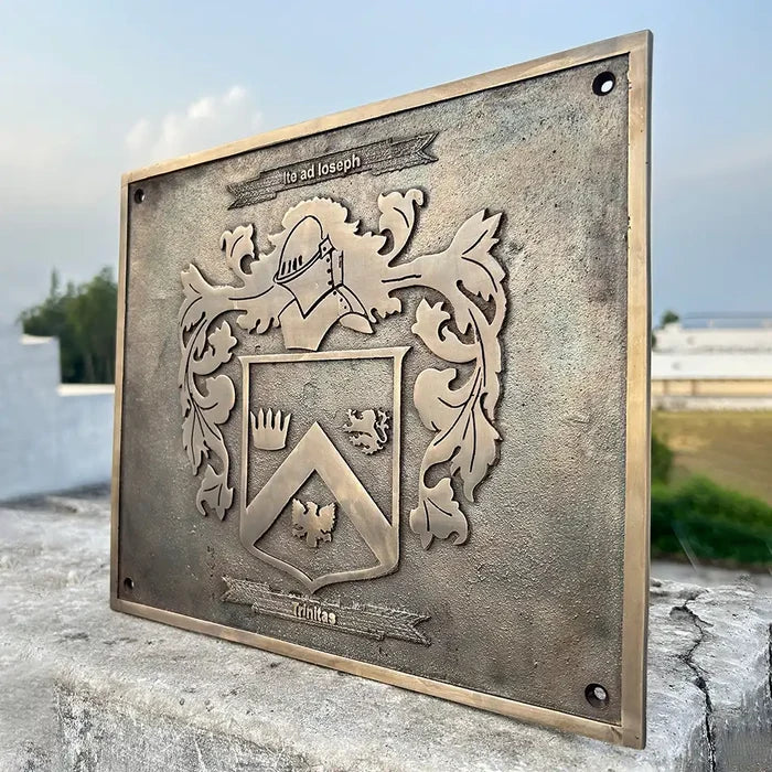 Bronze plaque with a classic design with a crest design on a stone surface outdoors.